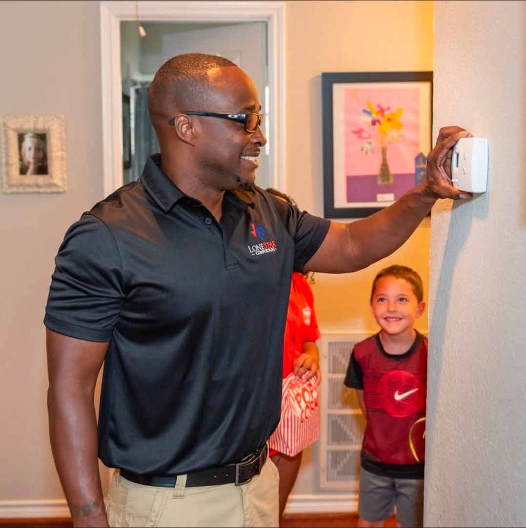 Lone Star Comfortaire technician helping family with thermostat